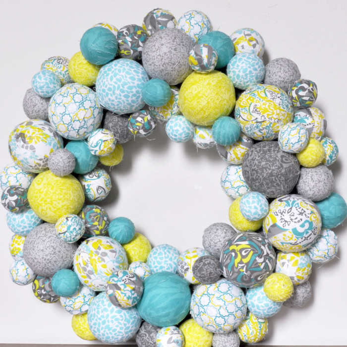 Fabric Ball Wreath - I am so excited about my spring wreath in aqua, lemongrass green, and gray patterns! It looks fabulous in our house and would look super cute in a nursery! {The Love Nerds} #crafts #springwreath 