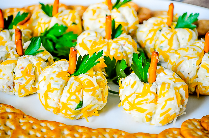 Small bacon ranch cheese balls are shape into adorable pumpkins with a pretzel stem and parsley garnish leaf. Works perfect for Thanksgiving appetizer