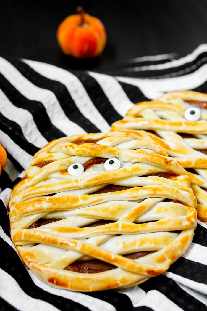Trick or Treat! Pumpkin Mummy Hand Pies make an adorable Halloween dessert! Plus, they're an easy recipe to serve and take with you! | The Love Nerds