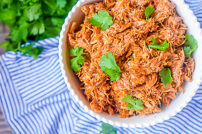 This 4 Ingredient Slow Cooker Pulled Pork Recipe is an incredibly easy family dinner recipe that is perfect for serving large groups like as game day food and as leftovers for the week! Toss with your favorite BBQ Sauce, Italian Dressing or even leave plain! | THE LOVE NERDS