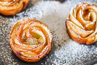 An apple rose pastry is definitely a statement piece for your holiday table! Apple Roses are gorgeous enough for Thanksgiving dessert or Christmas breakfast but easy enough to make anytime. With a dusting of powder sugar, everyone is going to love them! | The Love Nerds #appledessert #holidaydessert #holidaybreakfast #applepastry