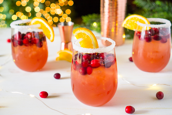 The Orange Cranberry Margarita is an easy holiday cocktail recipe for Thanksgiving and Christmas! The sweetness of the orange complements the tartness of the cranberries, making it a big crowd pleaser. Plus, sipping a holiday drink garnished with fresh cranberries and orange slices is festive and fun! | The Love Nerds #cranberryorange #holidaycocktail #christmasmargarita