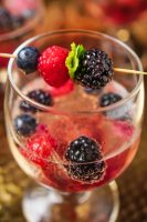 Toast your holiday festivities with a Berry Champagne Cocktail. Lightly sweetened with blackberries, blueberries and raspberries with a gorgeous first impression for your holiday parties. Just think how pretty your midnight toast could be with this as your New Year's Eve cocktail!  | The Love Nerds #newyearsdrinks #champagnecocktailrecipes