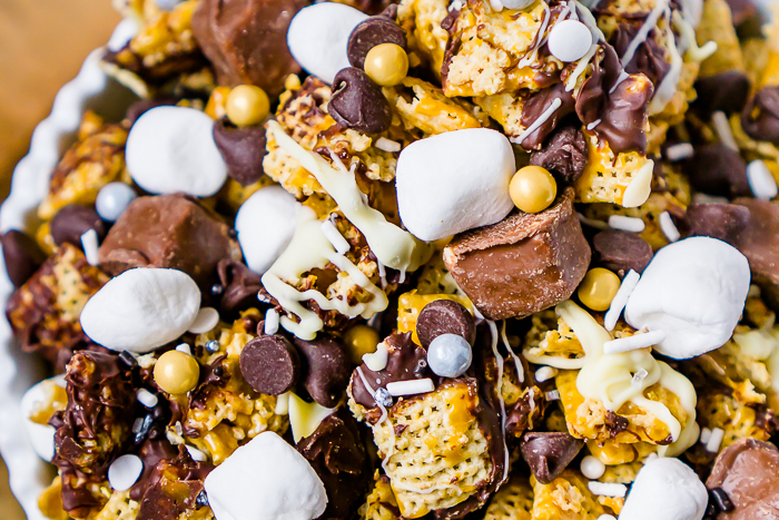 Treat your guests and yourself to a decadent sweet party mix! This caramel, chocolate and white chocolate party mix recipe is topped with candy bites, marshmallows and even more chocolate! Double Chocolate Caramel Snack Mix is an easy dessert recipe for any party, but it's definitely my favorite New Year's Eve dessert when topped with gold and silver sprinkles! 