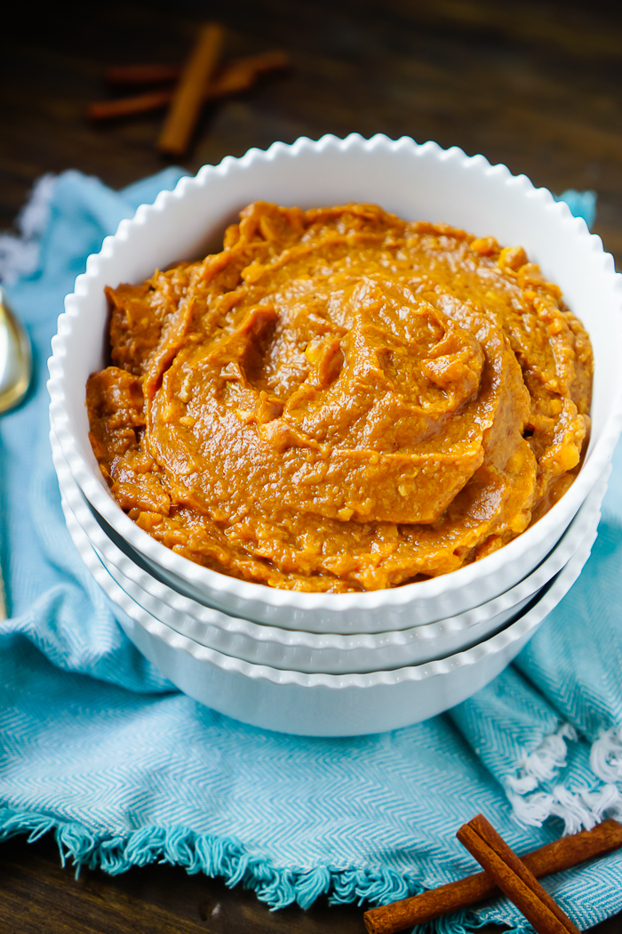 Sweet Potatoes Mashed, which make an Easy Side Dish for thanksgiving, sits inside a stack fo white bowls. 