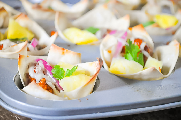  Hawaiian Barbecue Chicken Wonton Cups are a must make game day appetizer!! Crisp baked wonton cups are filled with bbq chicken, pineapple, onions, cheese and cilantro for a savory bite with subtle hints of sweet citrus! 