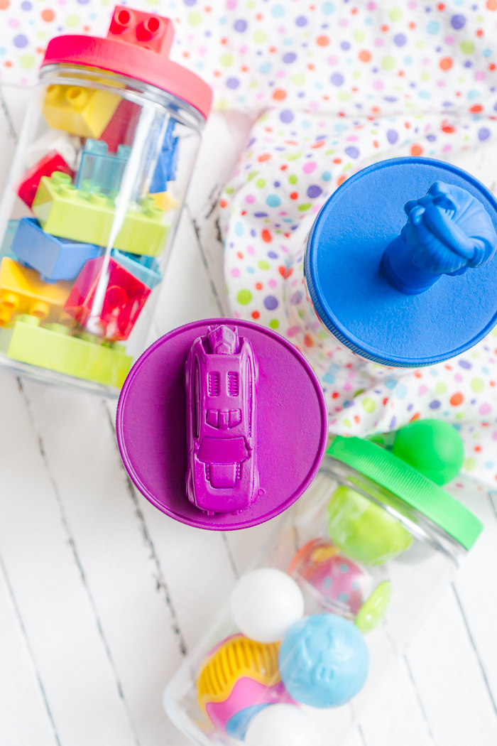 All parents know that the playroom can easily become a huge mess so I've created some colorful DIY Playroom Storage Containers! Create lids with easily identifiable toy labels in bright colors thanks to Plasti Dip. 