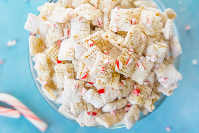 White Chocolate Peppermint Puppy Chow (or Muddy Buddies) combines candy canes and white chocolate for a tasty holiday snack mix that's perfect for your Christmas parties! It also makes a great holiday gift for your neighbors, coworkers and friends! | The Love Nerds