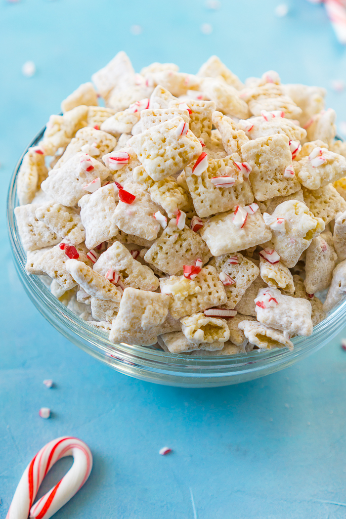 White Chocolate Peppermint Puppy Chow (or Muddy Buddies) combines candy canes and white chocolate for a tasty holiday snack mix that's perfect for your Christmas parties! It also makes a great holiday gift for your neighbors, coworkers and friends! | The Love Nerds