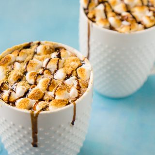 Indulge in an extra rich treat this winter season with this easy S'Mores Hot Chocolate! Rich hot chocolate topped with toasted marshmallows, graham cracker crumbs and chocolate drizzle! 