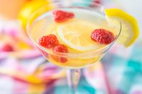 Coupe champagne glass with a white wine sangria with lemons and raspberries