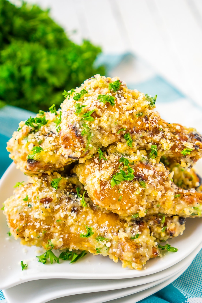 Chicken wings covered in garlic and parmesan with a parsley garnish 
